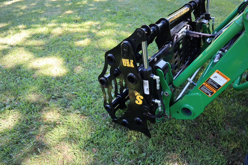 Green John Deere tractor with black Stinger Attachment, logo, and bold yellow Made In USA lettering