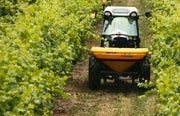 Tractor with BEFCO Turbo-Hop 303 spreader navigating a vineyard, showcasing its versatility and precision.