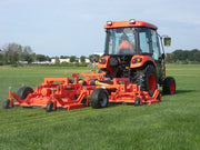 Tractor with BEFCO CYCLONE FLEX gang mower, mowing a large grassy field, highlighting its wide-area coverage.