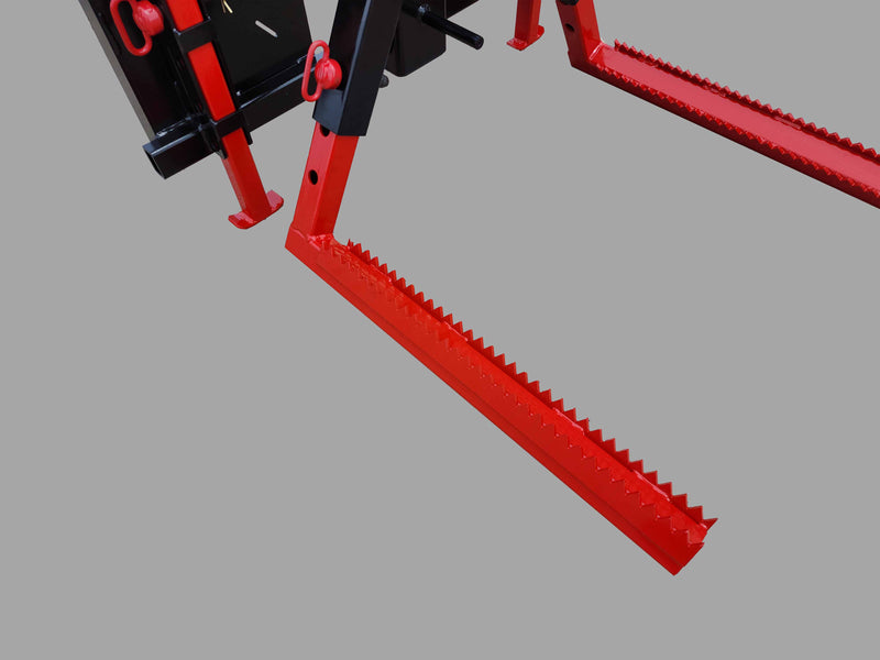 Close-up of the red serrated arms on the skid steer tire grabber attachment, showcasing its gripping mechanism.