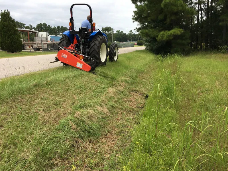 Tractor using BEFCO Sickle Bar Mower on roadside, demonstrating cutting capability on uneven terrain.