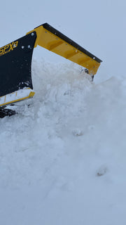 SPX8 snow pusher in action, pushing snow, showcasing its efficiency and robust construction.