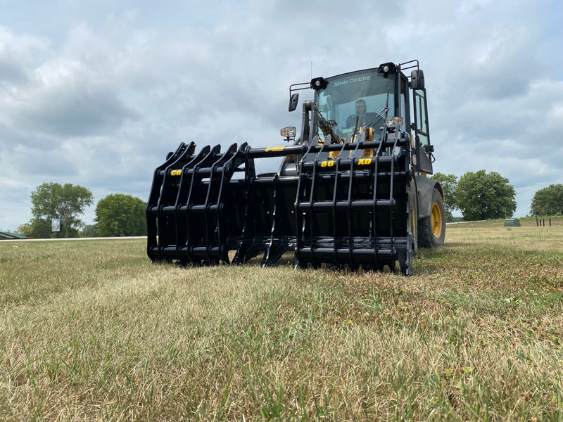Yellow John Deere tractor with closed black Stinger attachment claw