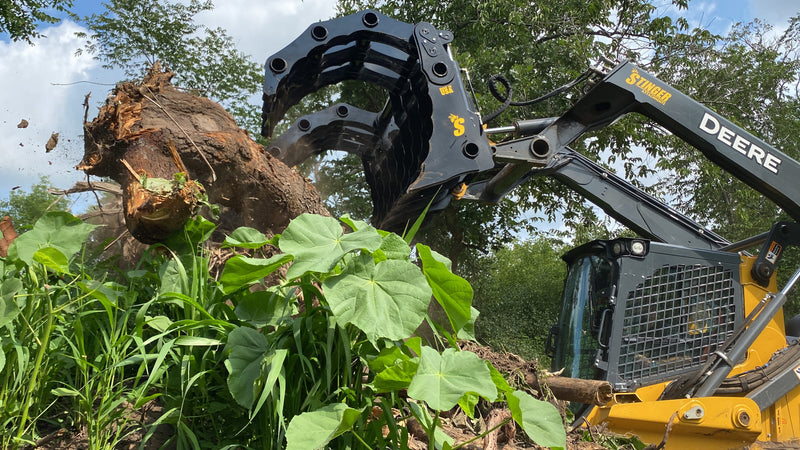 Close up of CG-XD Clam Grapple from Stinger Attachments operating in a forested area