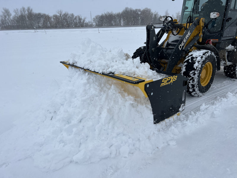 SPXR snow pusher attached to a loader, demonstrating its capability to handle large snow volumes.