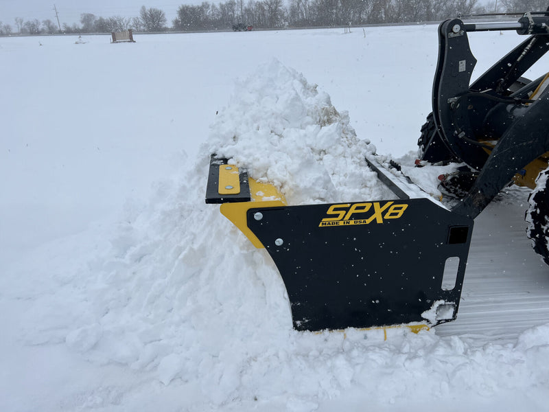 Close-up of SPX8 snow pusher with snow, showing its durable steel construction and design.