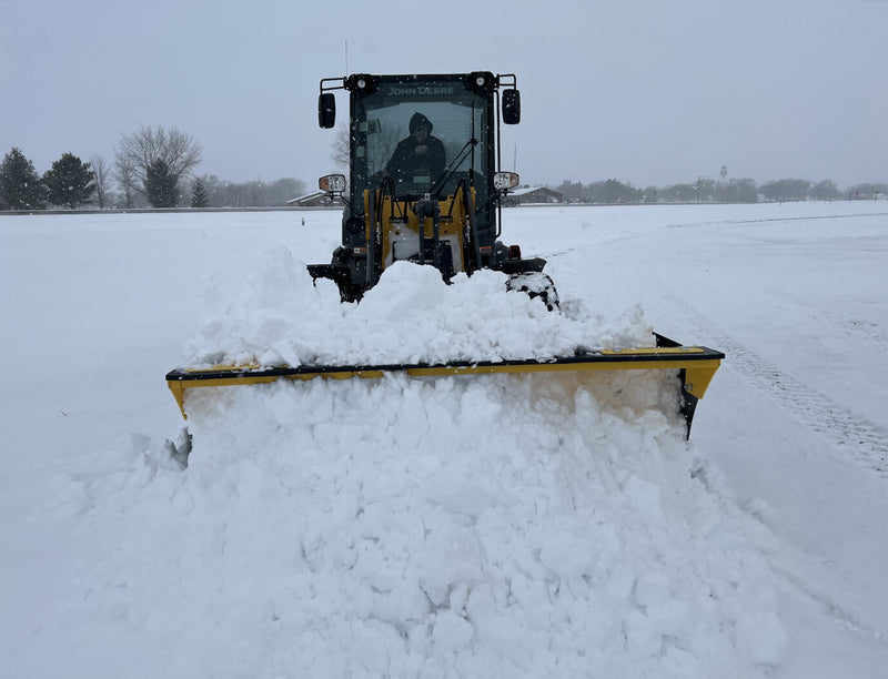 Front view of SPXR snow pusher in use, effectively clearing snow with its wide blade and sturdy build.