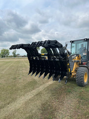 Slightly angled black Stinger Attachment clam grapple attached to John Deere Tractor and operator
