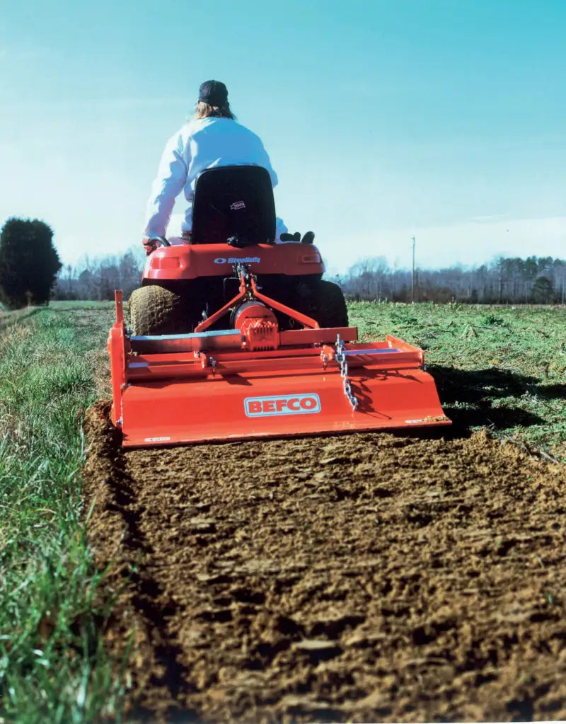 BEFCO TILL-RITE T30 rotary tiller in action, tilling a field, attached to a compact tractor.