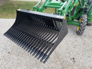 Slightly angled green John Deer tractor with black tractor rock bucket RK-72 Stinger Attachment