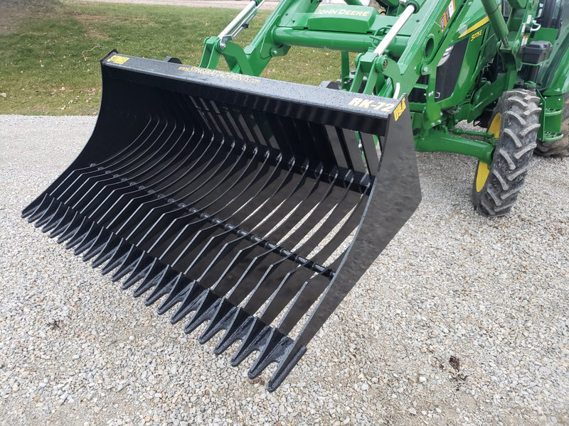Slightly angled green John Deer tractor with black tractor rock bucket RK-72 Stinger Attachment